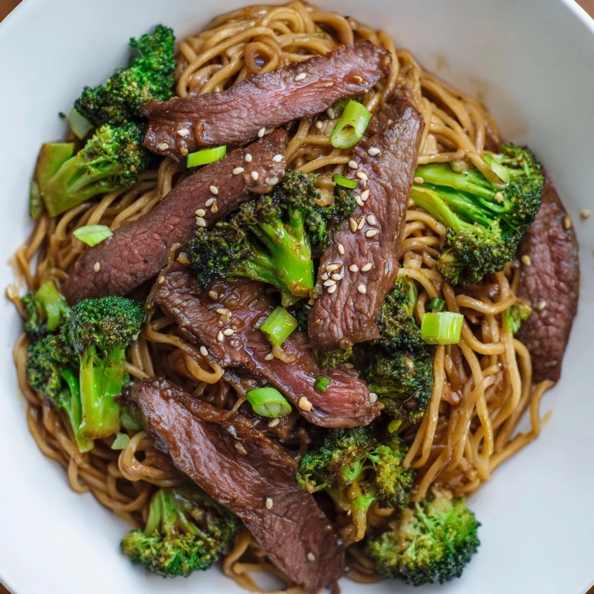 A warm serving of Beef and Broccoli Lo Mein topped with toasted sesame seeds, featuring tender beef and crisp broccoli on savory noodles.