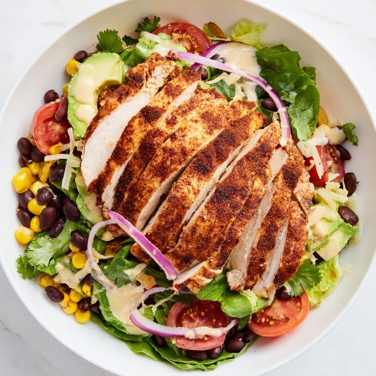 Southwest Chicken Salad with Chipotle Lime Dressing features juicy sliced chicken, black beans, corn, and shredded cheese tossed in a creamy, spicy dressing.