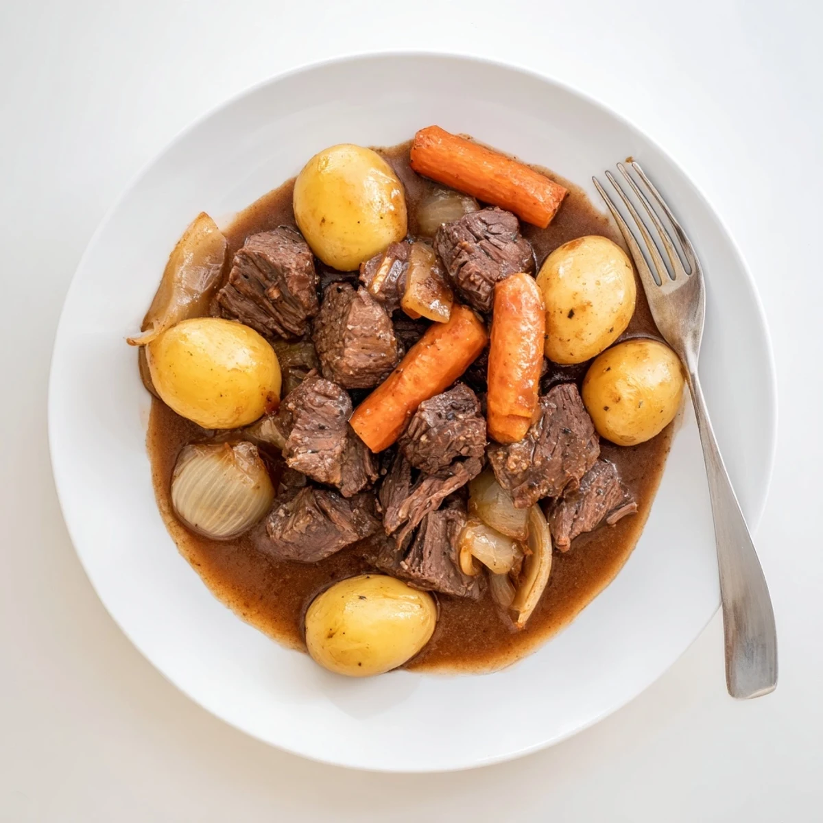 Hearty slow cooker pot roast with carrots and potatoes served in a rustic bowl, garnished with rosemary and a drizzle of gravy.  