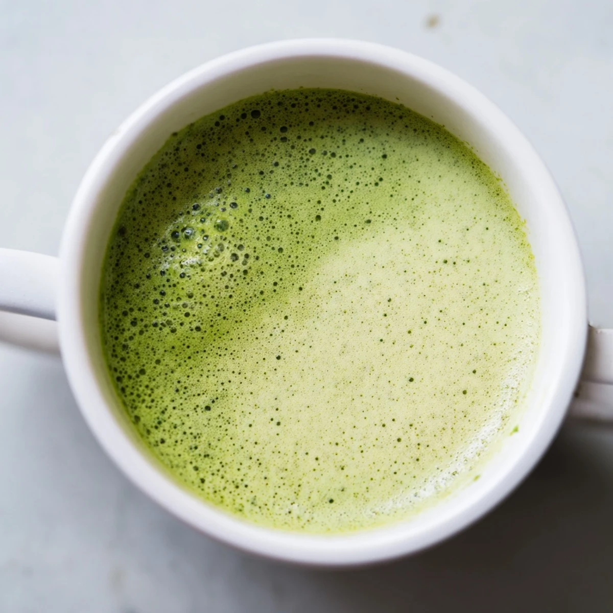 Creamy vegan matcha latte with almond milk, served warm for a soothing morning antioxidant boost.