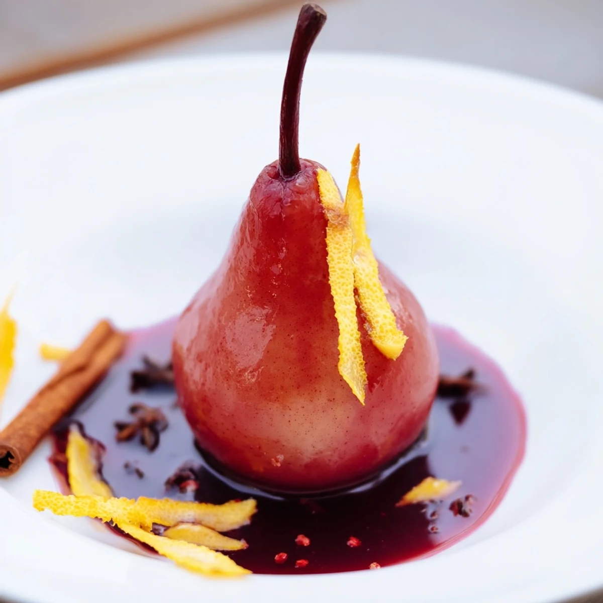 Four elegant Romantic Poached Pears in Grape Juice sit in a glossy reduction, garnished with fresh mint leaves for a romantic dessert.  
