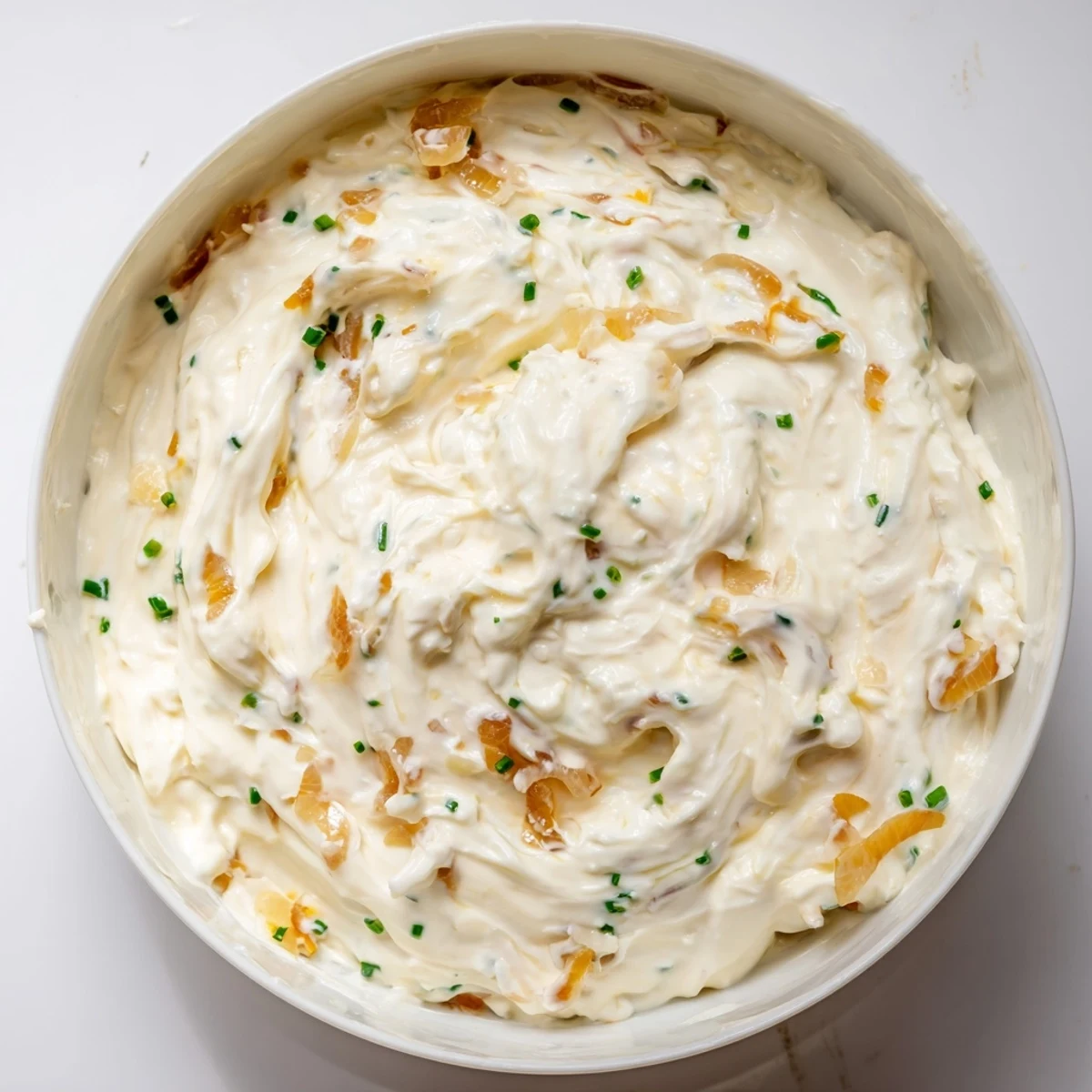A bowl of Game Day Onion Dip surrounded by crispy potato chips, ready for a party.