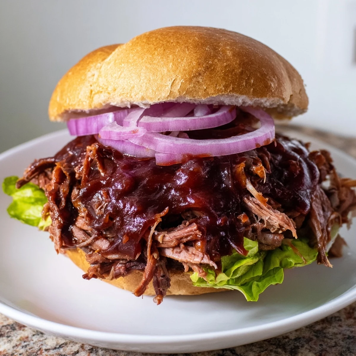 Tender shredded beef bathed in smoky BBQ sauce fills these slow roasted pulled beef sandwiches, served on a toasted bun ready for a family gathering.