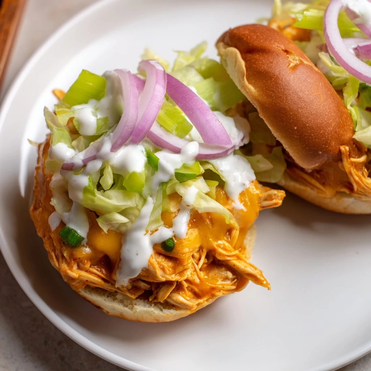Golden Buffalo Chicken Sliders with Ranch Dressing and crisp lettuce on soft buns, served on a platter for game day.