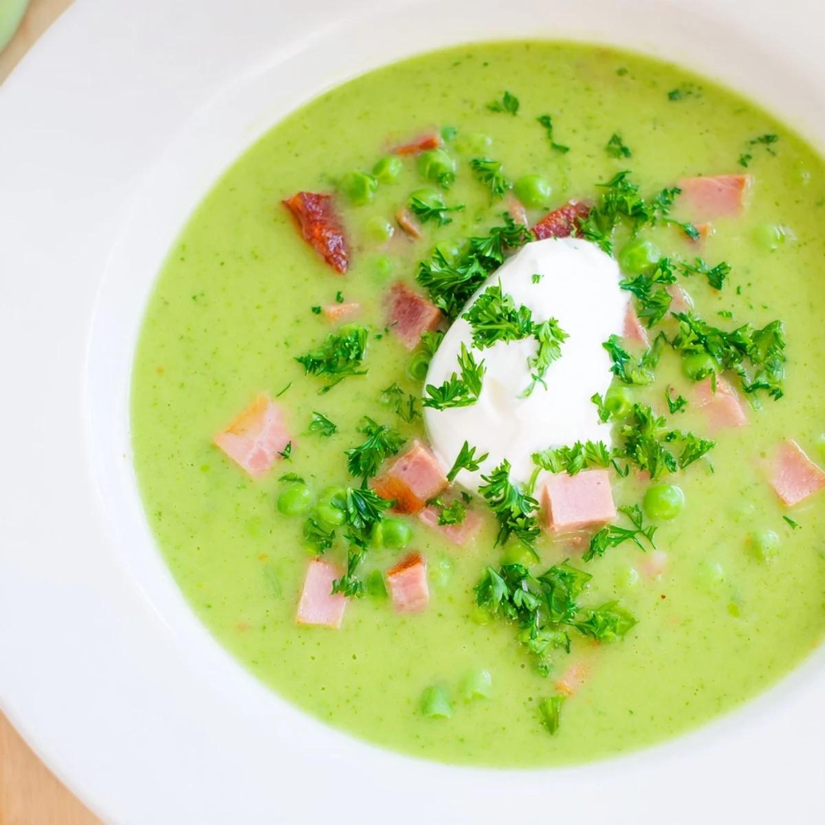 Steaming bowl of Spring Pea Soup with Ham and Turkey, highlighting the bright green puree and diced vegetables, perfect for a comforting lunch.