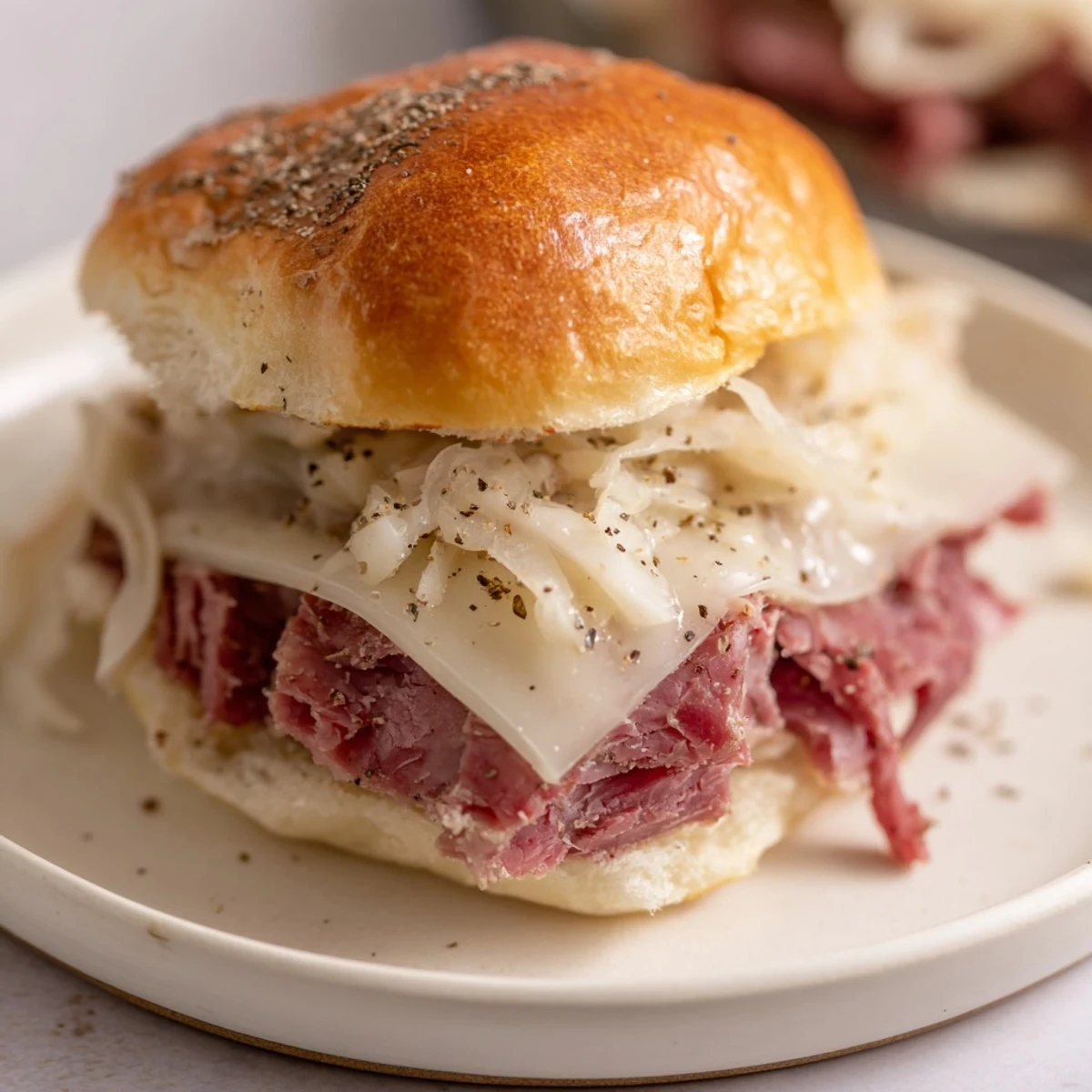 Golden-toasted corned beef sliders with melted Swiss cheese and tangy sauce on soft Hawaiian rolls, perfect for game day.  