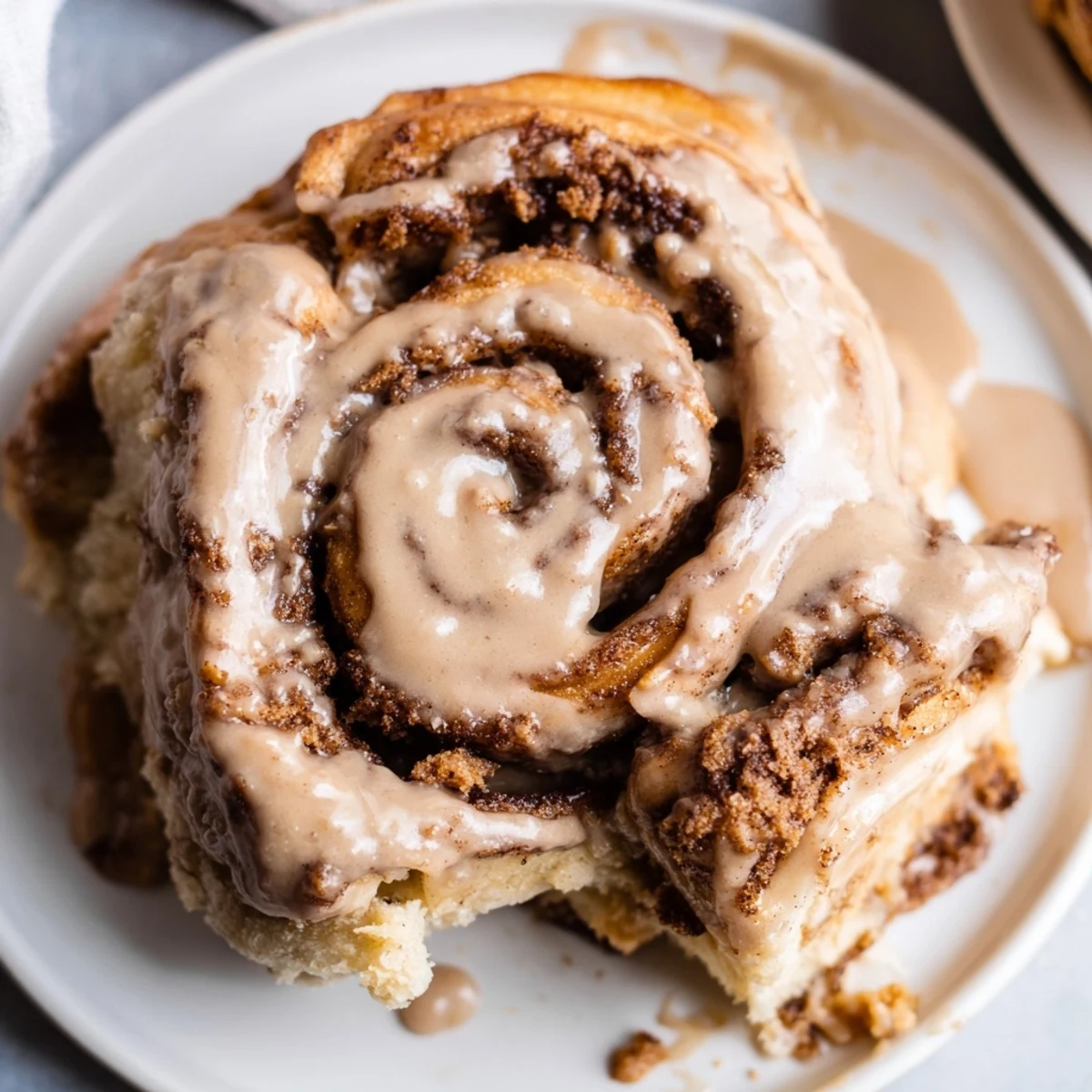Overhead view of Soft and Gooey Biscoff Cinnamon Rolls on a marble counter, garnished with crumbs and ready for brunch or dessert.