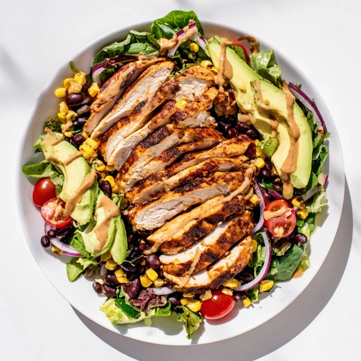 A hearty serving of chipotle lime chicken salad with black beans, corn, and tangy lime dressing.