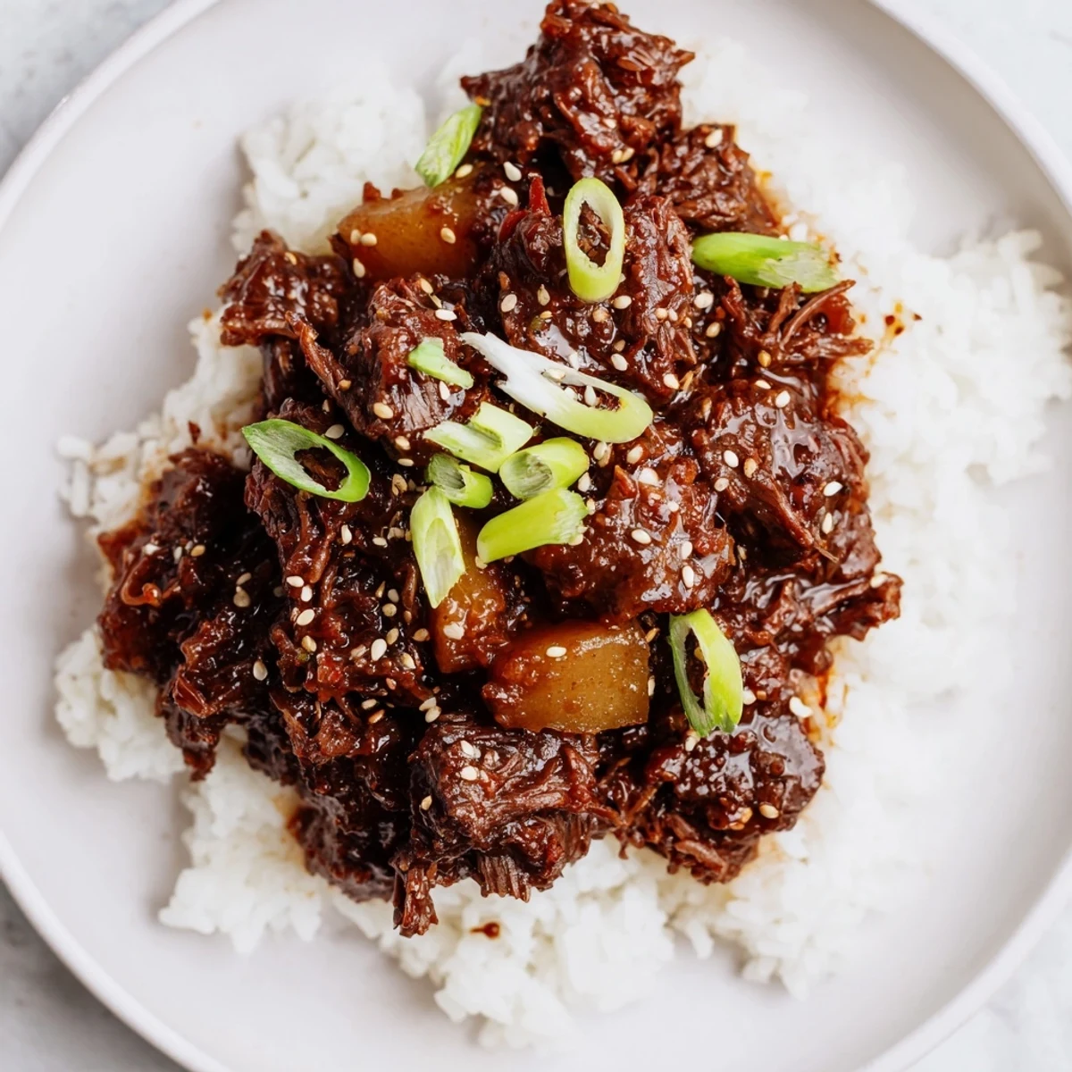 A slow cooker filled with savory-sweet Korean beef stew, bubbling with a glossy sauce and tender meat chunks, ready for serving over rice.