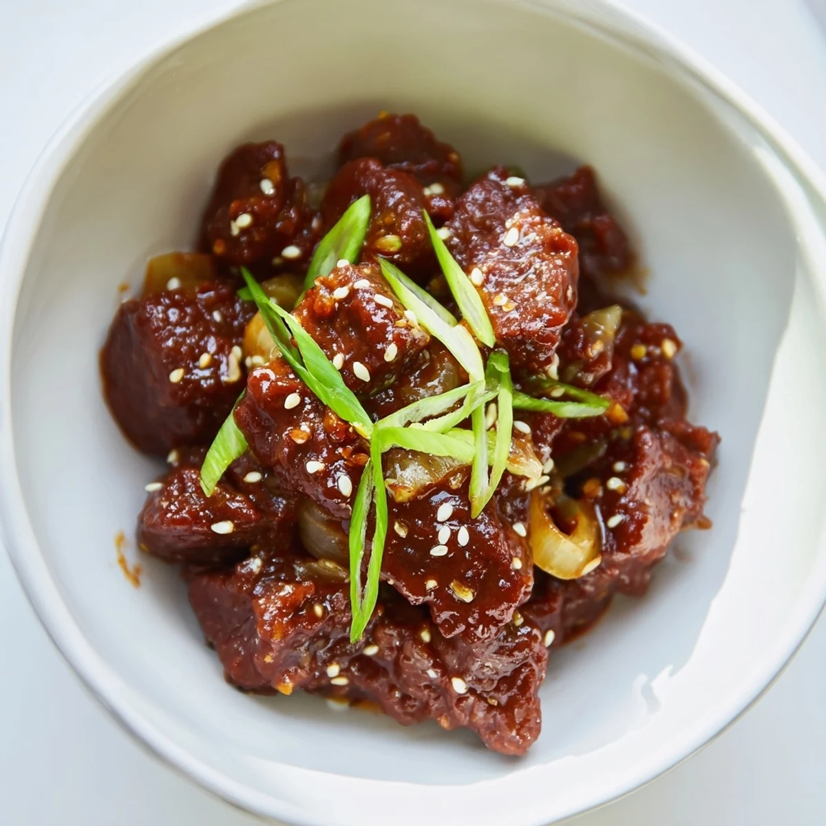 Steaming Crock Pot Korean Beef in a slow cooker, garnished with green onions and sesame seeds over white rice.