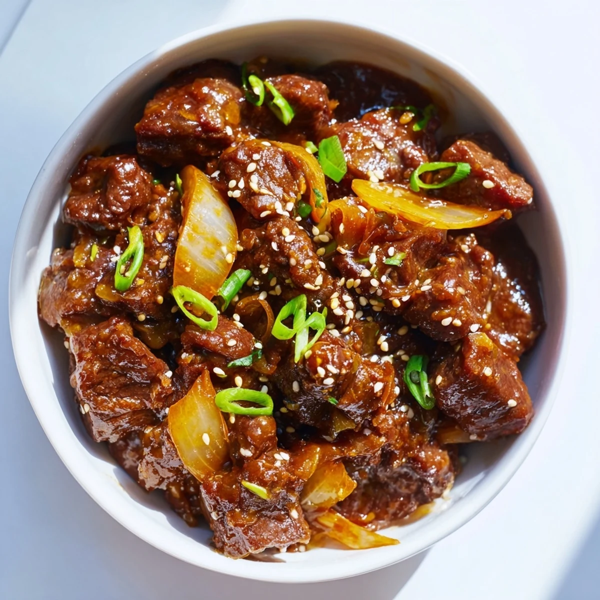 A serving of tender Crock Pot Korean Beef with spicy sauce in a bowl, ready to enjoy with chopsticks.