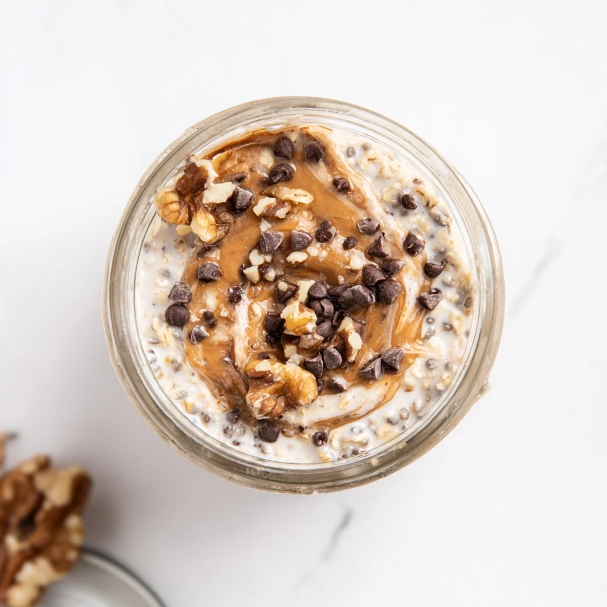 Creamy overnight oats swirled with almond butter and studded with mini chocolate chips, perfectly chilled for a sweet breakfast.