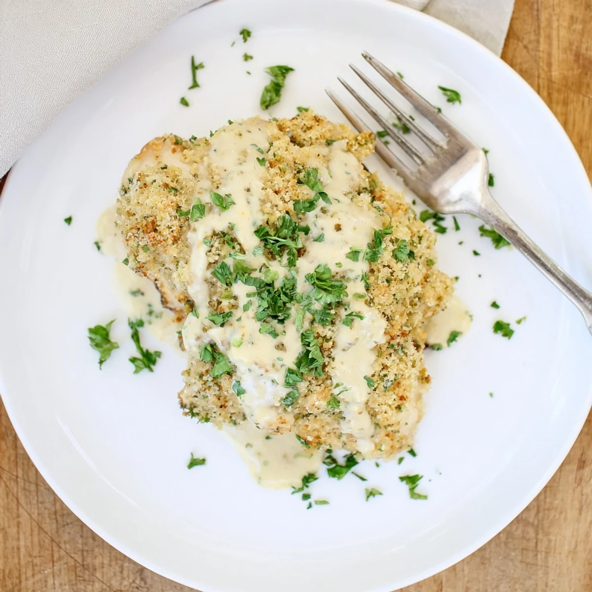 Longhorn Steakhouse Parmesan Crusted Chicken rests on a plate, golden crust bubbling with cheese, alongside a fresh salad and ranch drizzle.