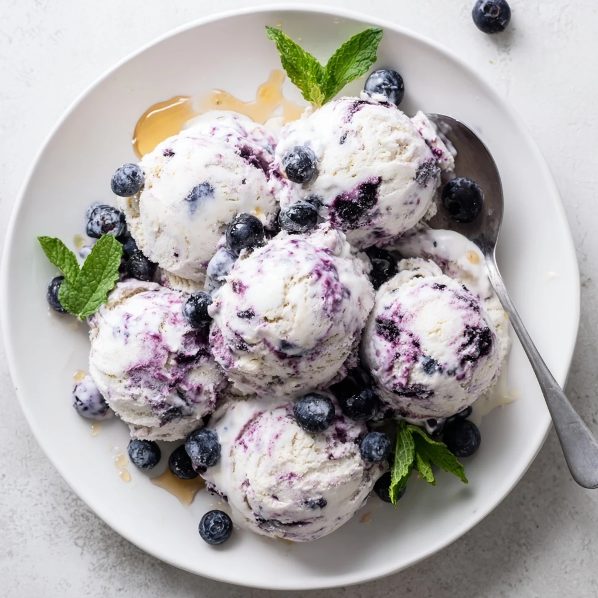 A bowl of homemade Blueberry Cottage Cheese Ice Cream with creamy scoops and fresh blueberry swirls.
