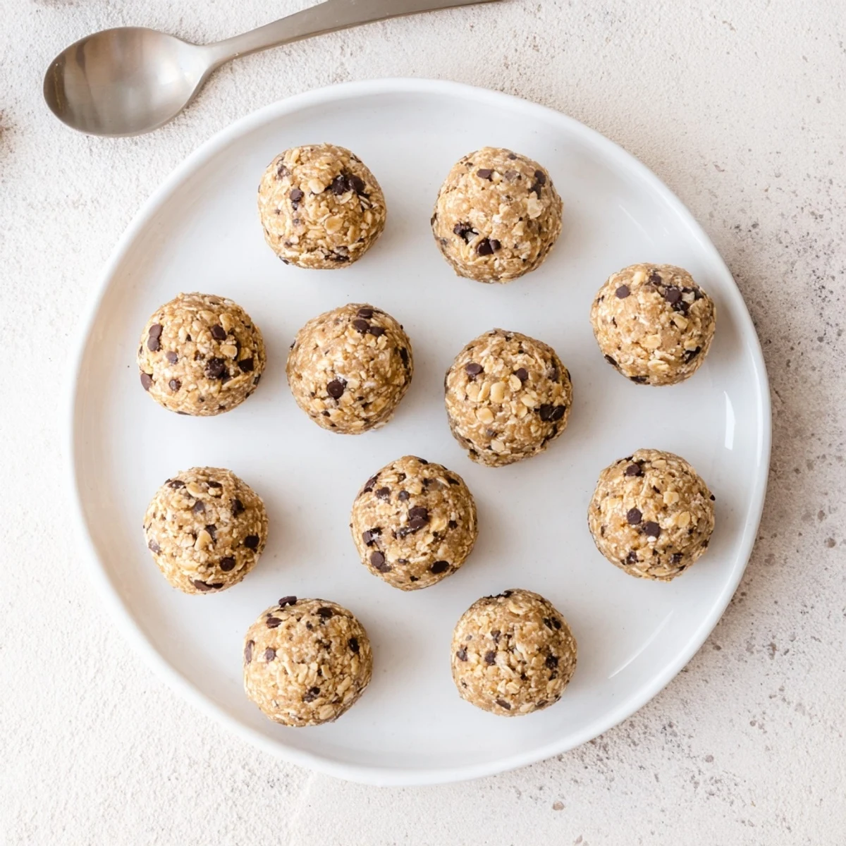 Mint chocolate chip protein balls stacked on a wooden board, suggesting a cool and refreshing post-workout snack.