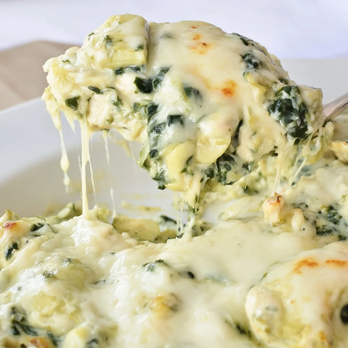 Golden bubbly spinach and artichoke chicken bake fresh from the oven with melted cheese topping