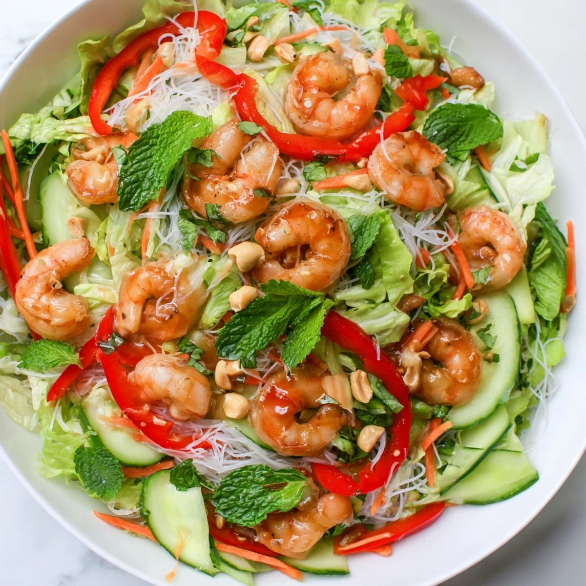 Fresh spring roll salad featuring julienned vegetables, rice noodles, and tender shrimp tossed in zesty homemade ginger lime dressing
