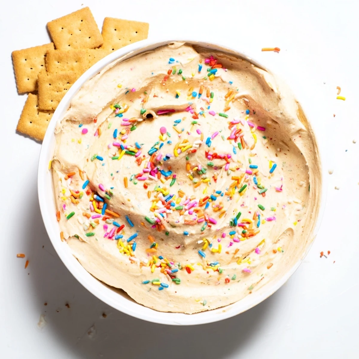 Protein-packed Dunkaroo dip spread topped with vibrant sprinkles alongside graham crackers for snacking