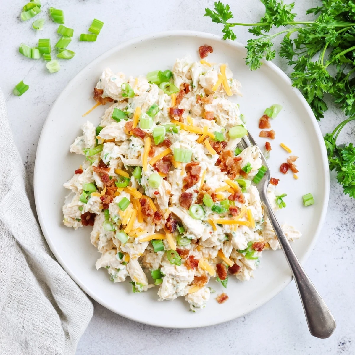 Scoop of zesty low carb jalapeno popper cottage cheese chicken salad served on crisp green lettuce leaves with garnish of green onions and parsley
