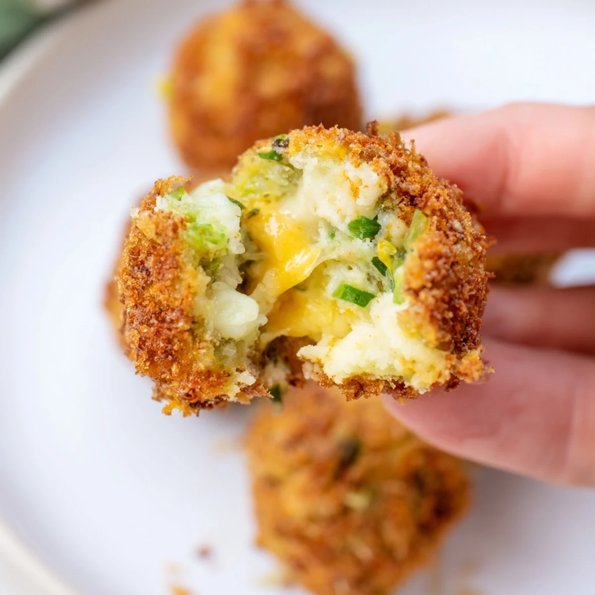 Golden brown crispy Cheesy Fried Colcannon Balls arranged on a serving platter with fresh herbs