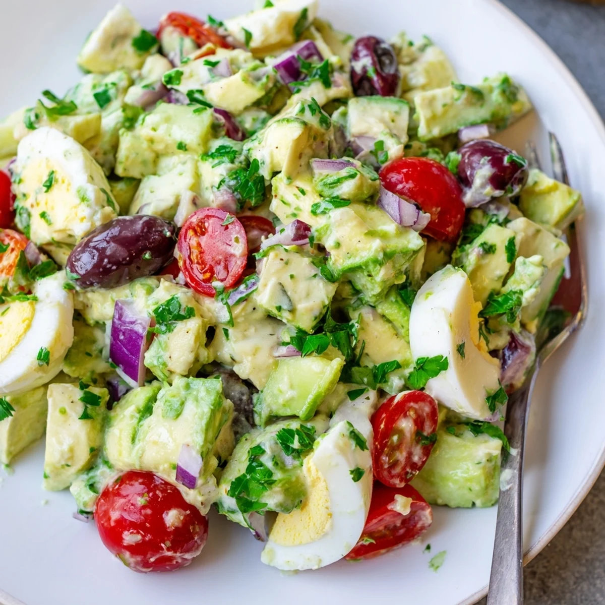 Vibrant zesty Mediterranean avocado egg salad featuring chunky avocado, Kalamata olives, and fresh parsley garnish