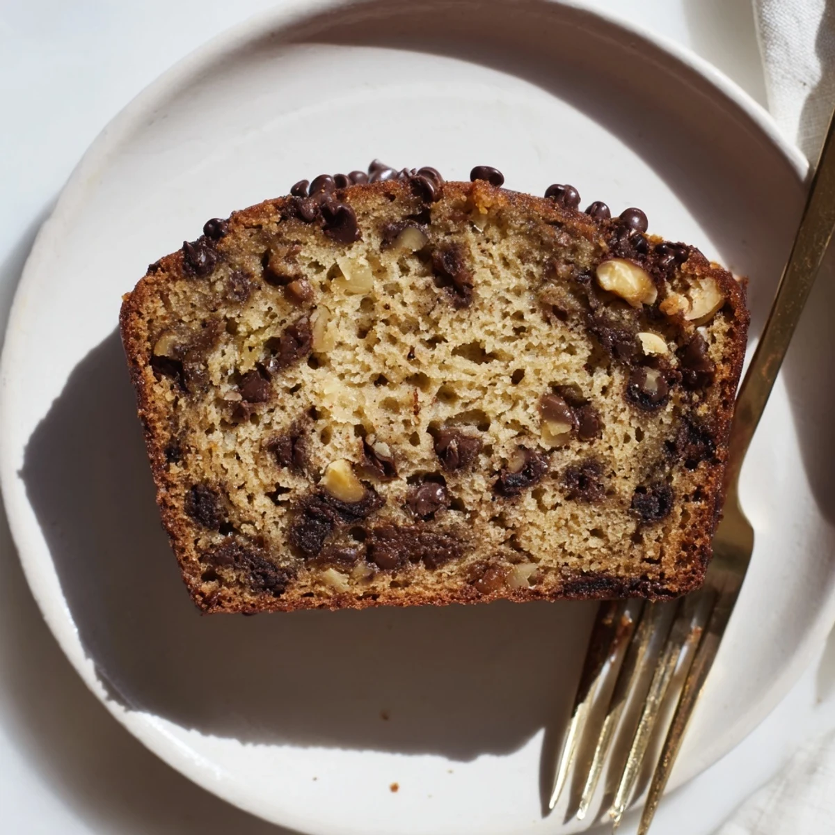 Freshly baked chocolate chip banana bread cooling on wire rack with golden crust