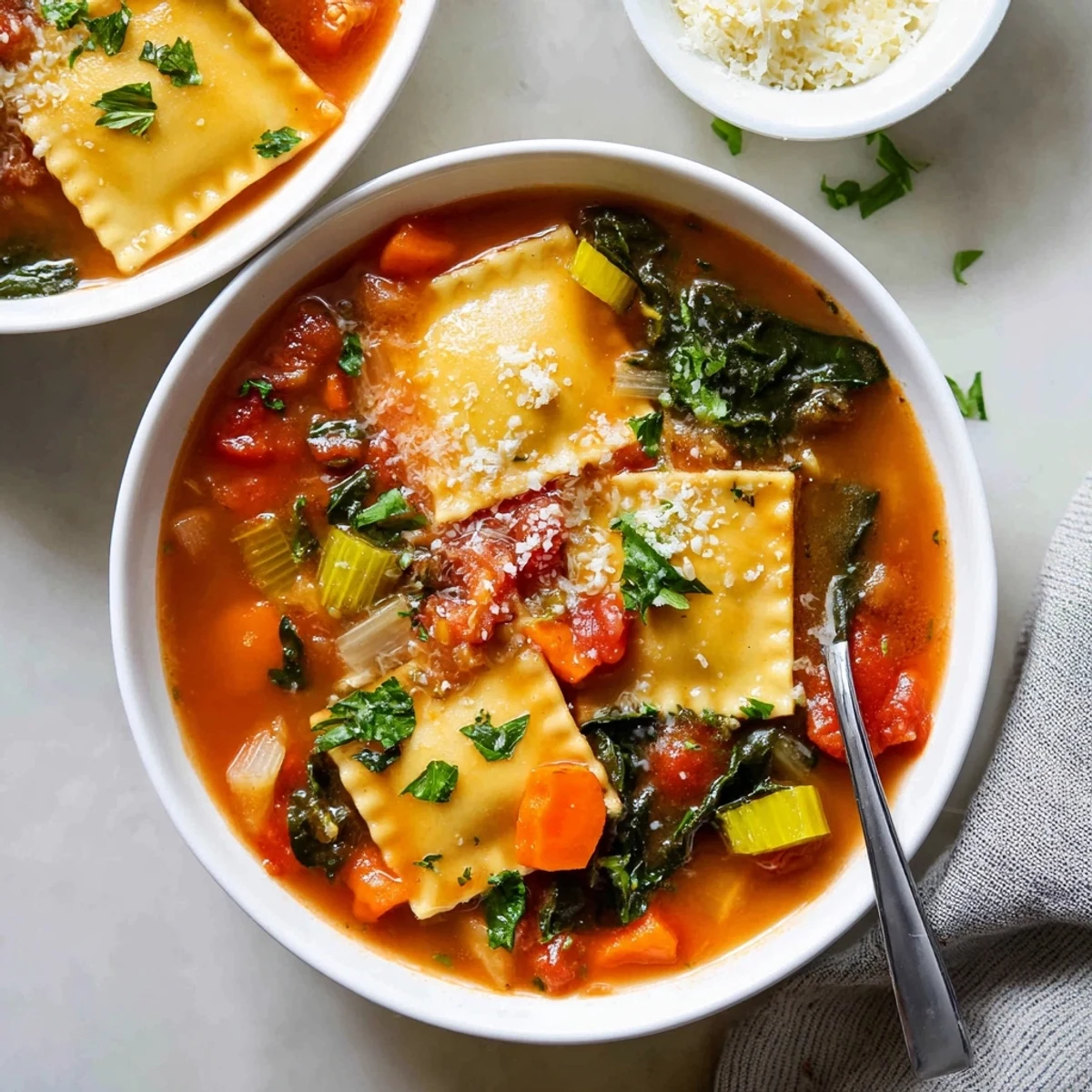 Golden ravioli floating in rich tomato soup topped with wilted spinach and parsley garnish