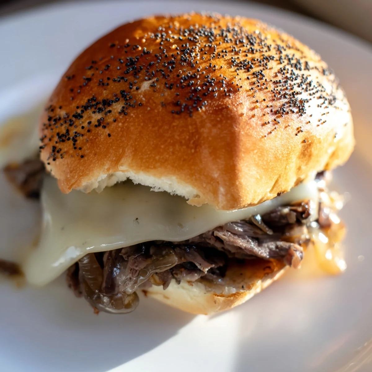 Mini French dip sliders with caramelized onions served alongside rich beef au jus for dipping