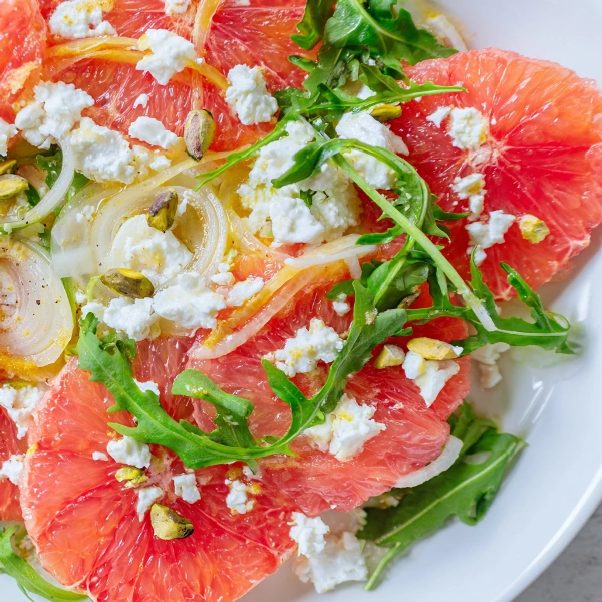 Colorful grapefruit goat cheese and fennel salad drizzled with light dressing and garnished with fennel fronds