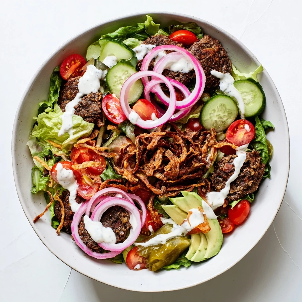 Low-carb smash burger bowl served with crispy fried onions, cheddar cheese, and tangy homemade sauce