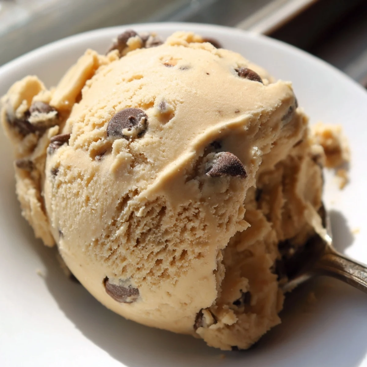 Edible chocolate chip cookie dough in a rustic bowl studded with melty chocolate chips