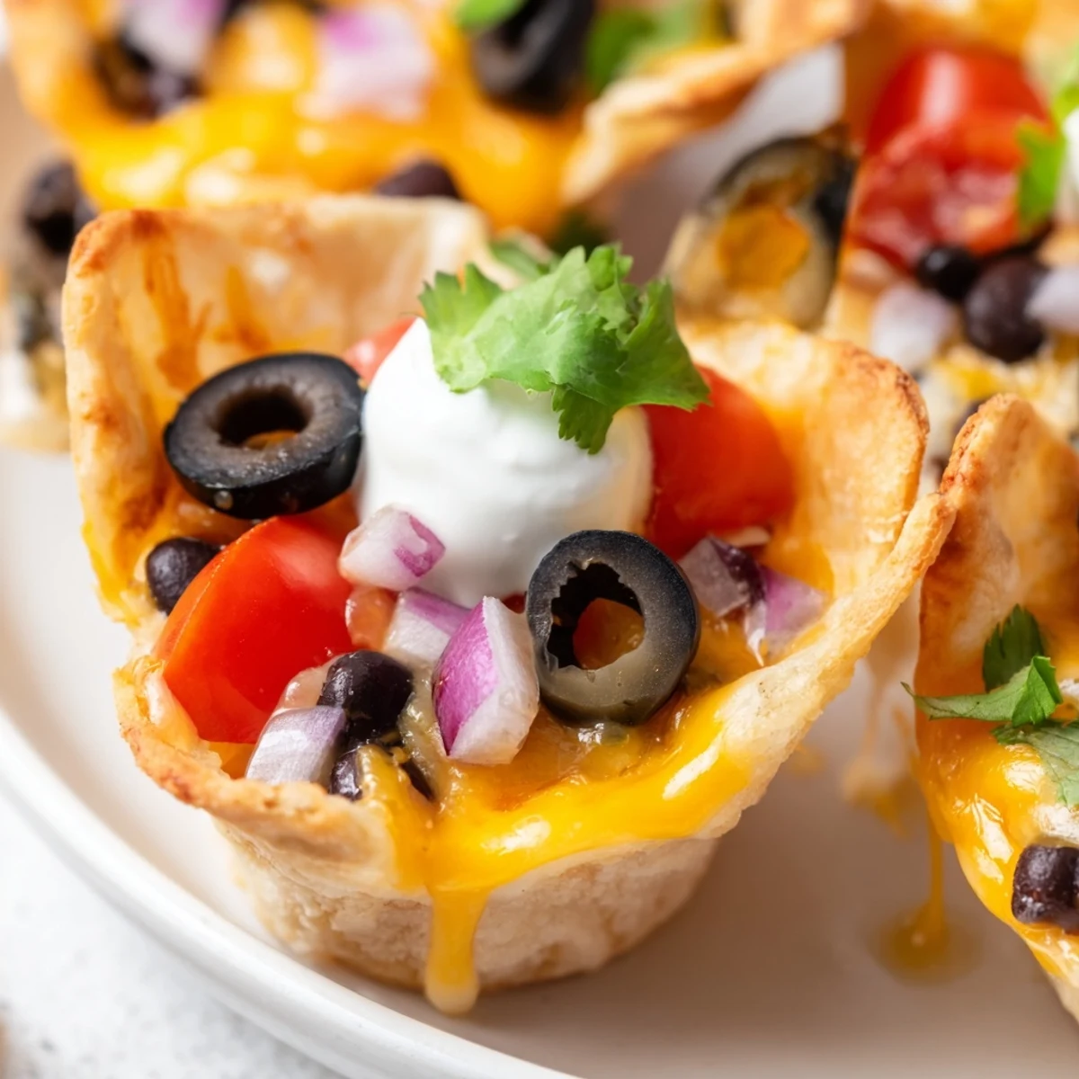 Crispy tortilla cups piled high with gooey cheese beans and zesty garnishes