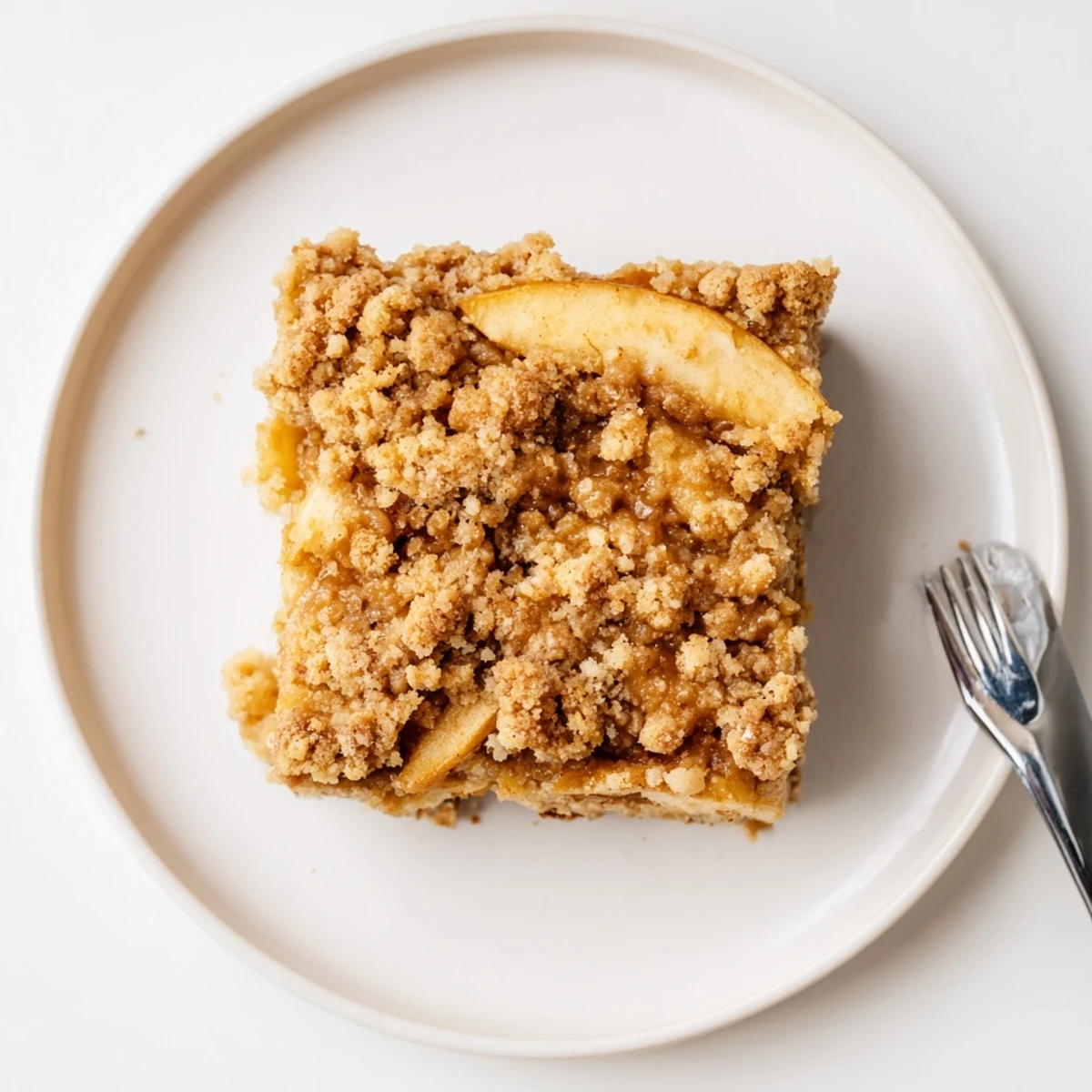 Golden caramel apple crumb bars with buttery streusel topping on a rustic baking sheet