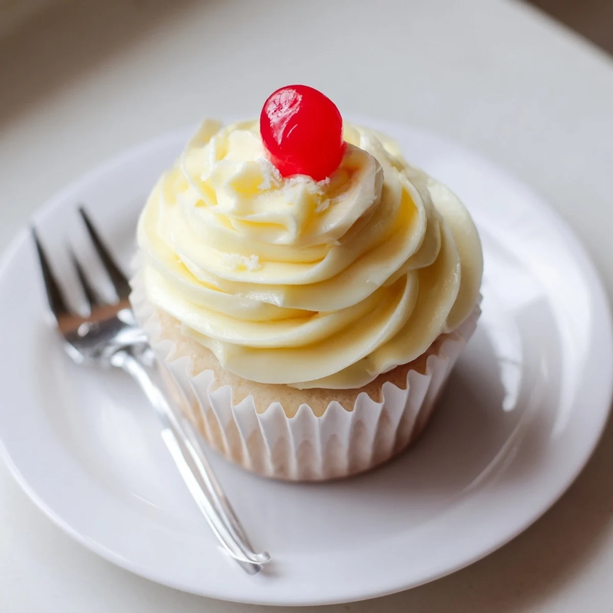A tray of Dole Whip Cupcakes with pillowy yellow frosting and pineapple wedge toppers