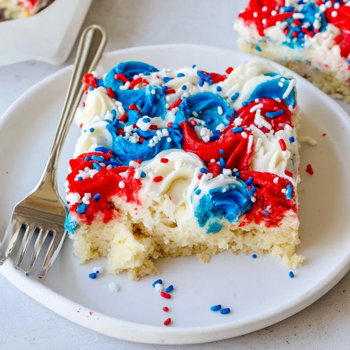 Patriotic Sugar Cookie Bars with swirled red, white, blue frosting and sprinkles