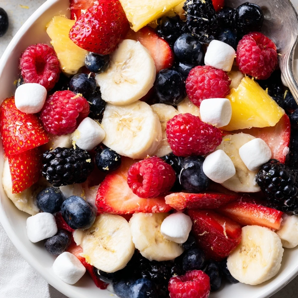 Red White And Blue Fruit Salad with juicy berries, pineapple, lime drizzle
