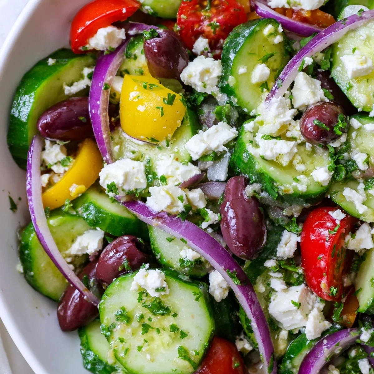 Colorful Mediterranean cucumber salad recipe with crisp vegetables, tangy feta cheese, and bright herbs in a bowl