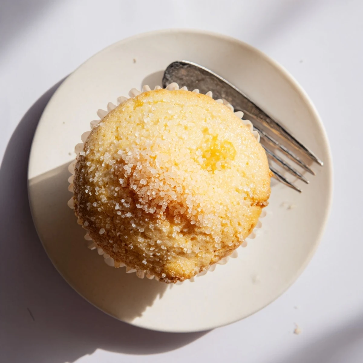 Golden lemon cream cheese muffins topped with sparkling sugar, fresh from the oven