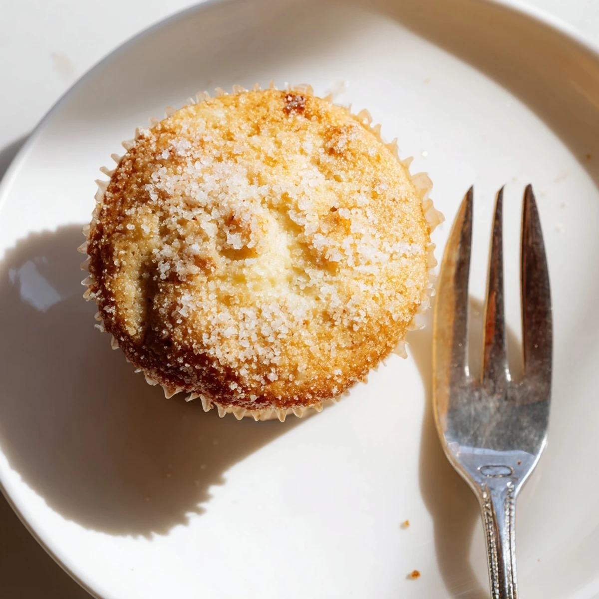 Twelve freshly baked lemon cream cheese muffins cooling on a wire rack