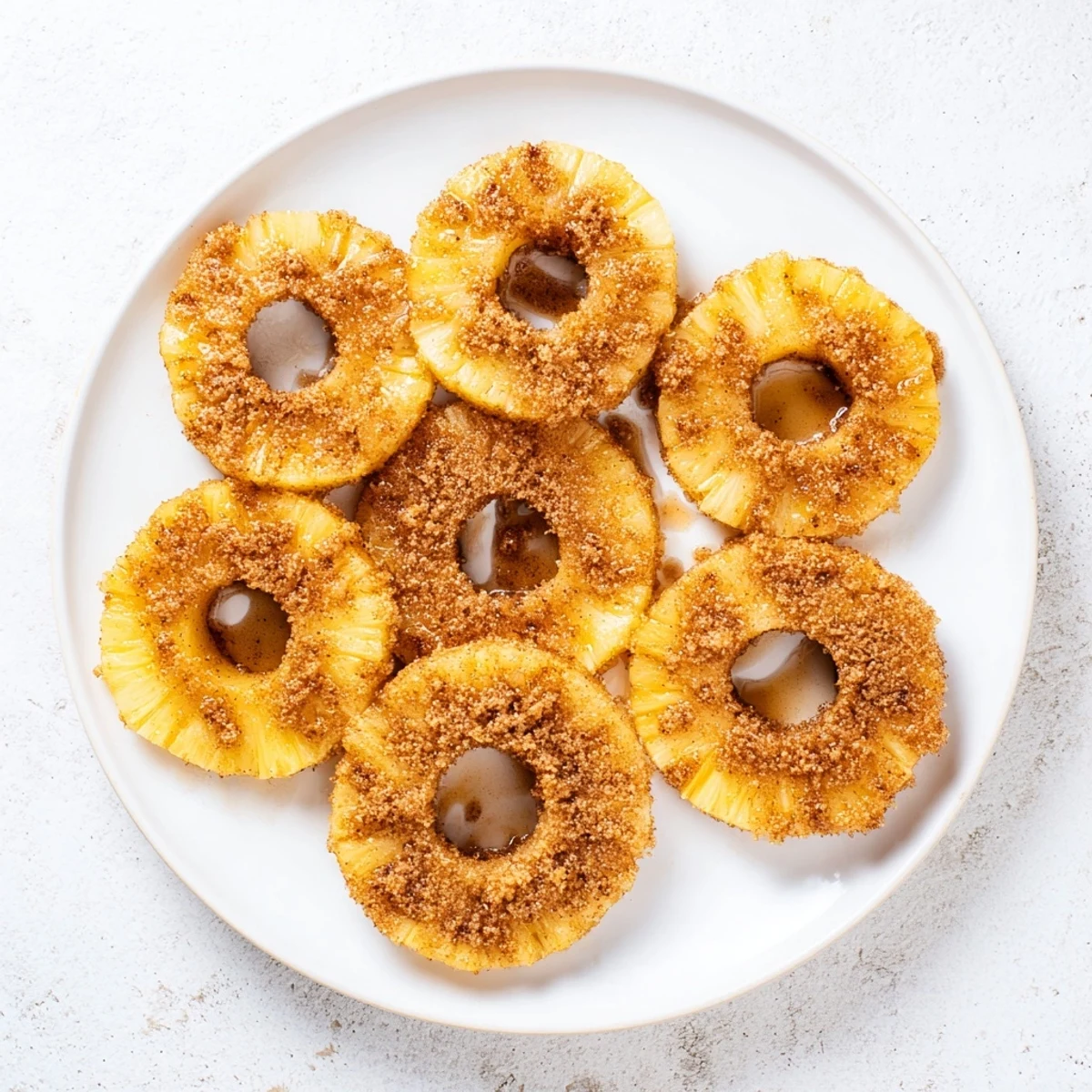Golden air fryer pineapple slices dusted with cinnamon sugar and caramelized edges