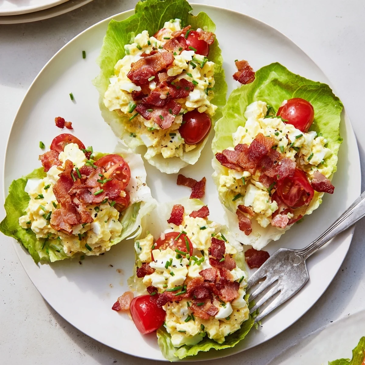 Crisp BLT Egg Salad Lettuce Wraps rolled in butter lettuce, garnished chives