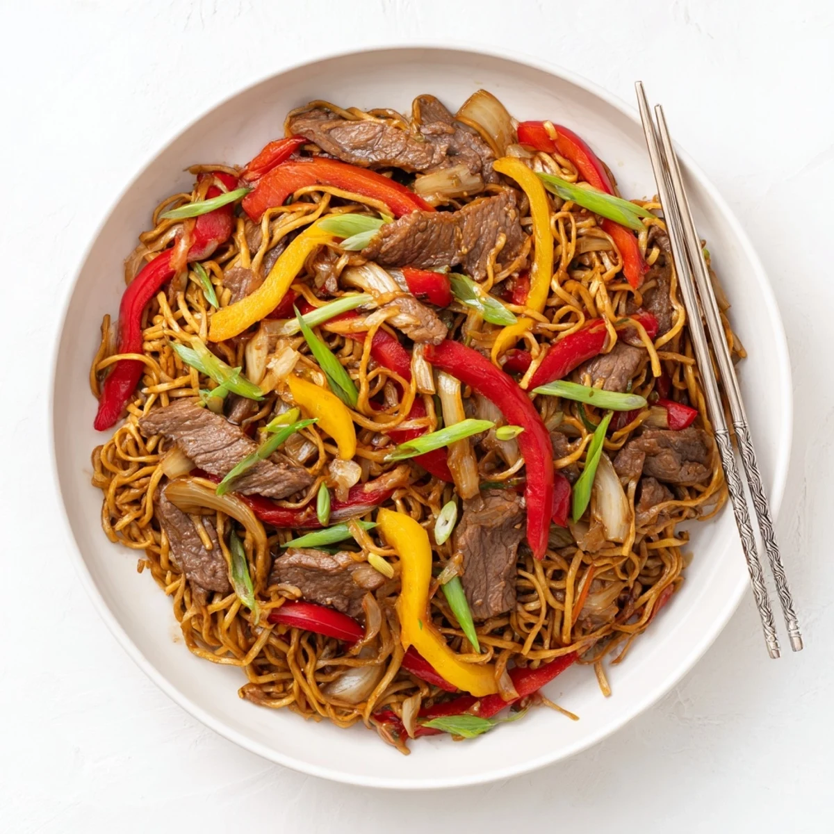 Beef chow mein stir-fry featuring tender beef strips with crisp bell peppers and onions