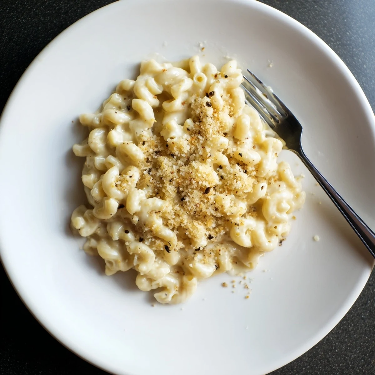 Baked mac and cheese casserole with golden breadcrumb crust and oozing sharp cheddar sauce