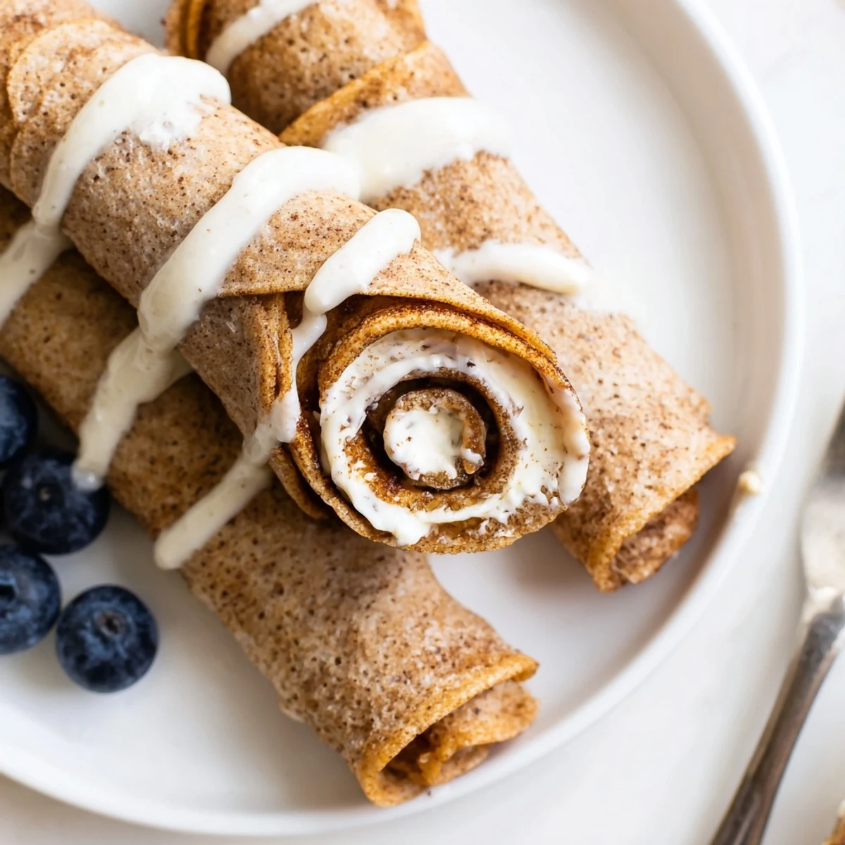 Stacked Cinnamon Roll Protein Crepes Recipe served warm with fresh berries.