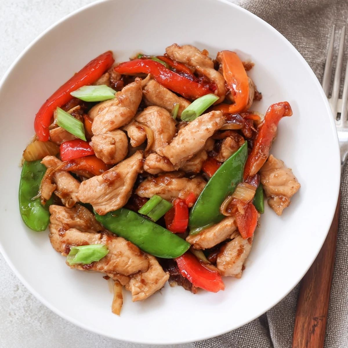 Tender Stir Fried Chinese Garlic Chicken tossed with crisp snow peas and bell peppers