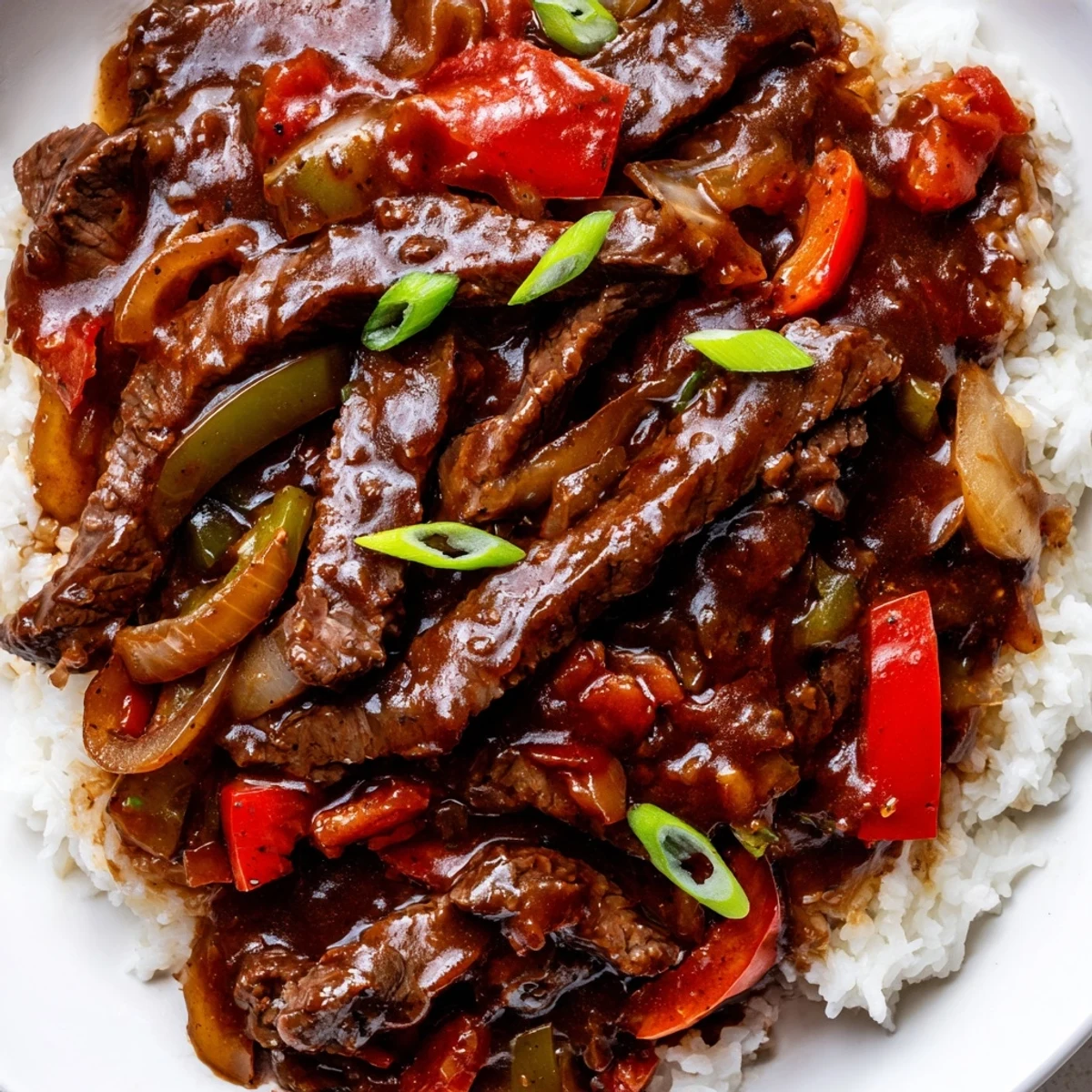 Tender slow cooker pepper steak with glossy bell peppers piled over fluffy white rice